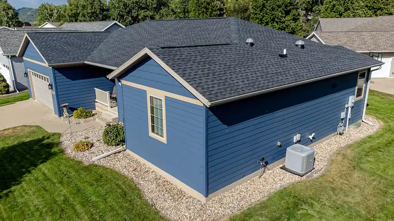 One-story house with blue lap siding and a dark shingle roof